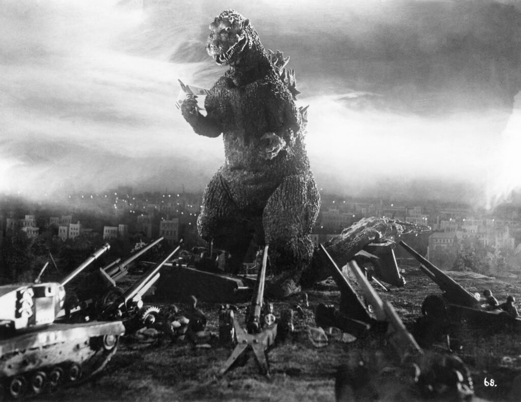 Giant monster attacking city with military defense.