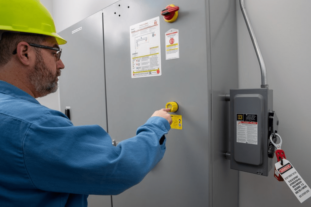 Worker operating electrical panel with safety lockout device
